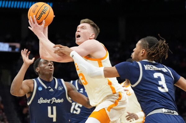 Tennessee guard Dalton Knecht drives to the basket between Saint Peter's guard Roy Clarke and forward Corey Washington during the first half of a first-round college basketball game in the NCAA Tournament, Thursday, March 21, 2024, in Charlotte, N.C. (AP Photo/Chris Carlson)
