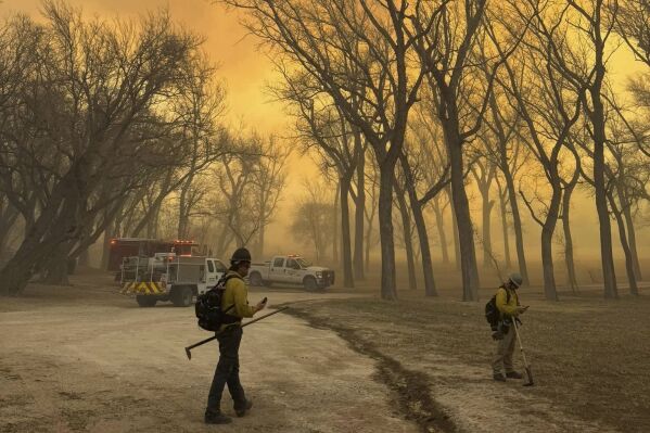 In this photo provided by the Flower Mound, Texas, Fire Department, Flower Mound firefighters respond to a fire in the Texas Panhandle, Tuesday, Feb. 27, 2024. A rapidly widening Texas wildfire doubled in size Tuesday and prompted evacuation orders in at least one small town. (Flower Mound Fire Department via AP)