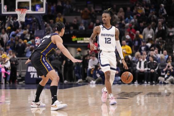 Memphis Grizzlies guard Ja Morant (12) brings the ball upcourt in front of Indiana Pacers guard Andrew Nembhard, left, during the first half of an NBA basketball game in Indianapolis, Saturday, Jan. 14, 2023. (AP Photo/AJ Mast)