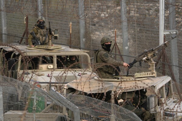 Israeli soldiers stand on armoured vehicles after crossing the security fence near the so-called Alpha Line that separates the Israeli-controlled Golan Heights from Syria, in the town of Majdal Shams, Dec. 21, 2024. (AP Photo/Matias Delacroix, File)
