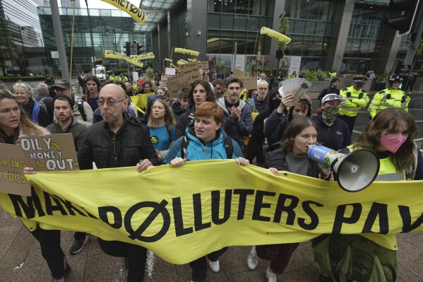 FILE - Environmental activists including Greta Thunberg, center left, march with other demonstrators during the Oily Money Out protest at Canary Wharf, in London, Oct. 19, 2023. “We cannot trust these politicians and we cannot trust the processes of the COPs because the fossil fuel industries are tightening their grip around their processes and dictating their outcomes,” Thunberg said. (AP Photo/Kin Cheung, File)