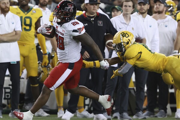 Texas Tech running back Tahj Brooks (28) runs past Baylor cornerback Chateau Reed (21) in the first half of an NCAA college football game, Saturday, Oct. 7, 2023, in Waco, Texas. (Jerry Larson/Waco Tribune-Herald, via AP)