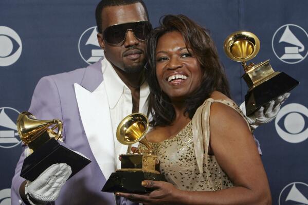 FILE - In this Feb. 8, 2006, file photo, Kanye West and his mother, Donda, hold his three awards backstage at the 48th Annual Grammy Awards in Los Angeles. West won for best rap album, solo and song. Kanye West unveiled his 10th studio album, “Donda,” in front of a packed crowd in Atlanta. His album was named after his mother, who died at the age of 58 following plastic surgery complications in 2007. (AP Photo/Reed Saxon, File)
