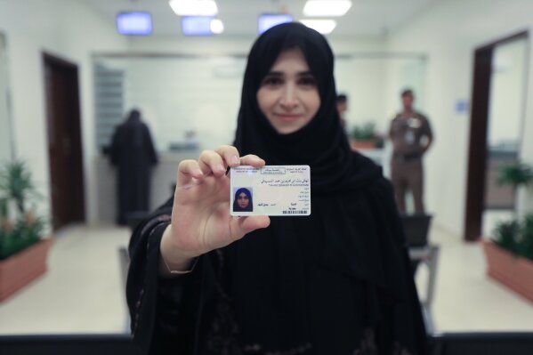 
              This image released by the Saudi Information Ministry, shows Tahani Aldosemani, Assistant Professor at Prince Sattam Bin Abdulaziz University in Al-Kharj, as she displays her brand new driving license, at the General Department of Traffic in the capital, Riyadh, Monday, June 4, 2018. Saudi Arabia has issued the first driving licenses to 10 women just weeks before the kingdom lifts the world's only ban on women driving, but the surprise move comes as a number of women who'd campaigned for the right to drive are under arrest. (Photos by Saudi Information Ministry via AP)
            