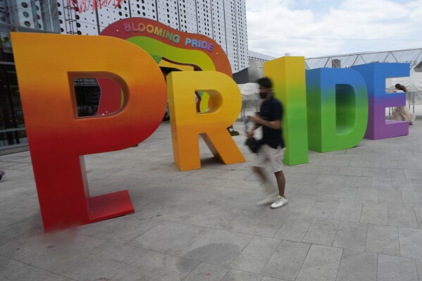 A Thai walks past a display on Bangkok Pride celebrations in Bangkok, Thailand, Thursday, May 30, 2024. Thailand is kicking off its celebration for the LGBTQ+ community's Pride Month with a parade on Saturday, as the country is on the course to become the first nation in Southeast Asia to legalize marriage equality. (AP Photo/Sakchai Lalit)