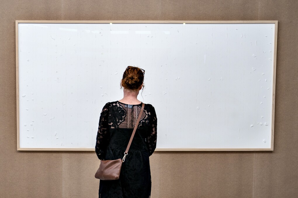 FILE - An empty picture frame by Danish artist Jens Haaning titled "Take the Money and Run", hangs at the Kunsten museum in Aalborg, on Sept. 28, 2021. Haaning, commissioned by the museum in northern Denmark to create a piece for its exhibition on labor conditions two years ago submitted two empty canvases. The exhibit caused a stir. A Danish court ruled last week that Jens Haaning has to repay 492,549 kroner ($69,894 ) to Kunsten Museum in Aalborg for the work. His lawyer, Peter Schønning, said Wednesday, Sept. 27, 2023, that the contemporary artist is appealing the ruling and declined further comment. (Henning Bagger/Ritzau Scanpix via AP)