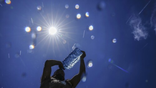 FILE - A man pours cold water onto his head to cool off on a sweltering hot day in the Mediterranean Sea in Beirut, Lebanon, Sunday, July 16, 2023. In the past 30 days, nearly 5,000 heat and rainfall records have been broken or tied in the United States and more than 10,000 records set globally, according to the National Oceanic and Atmospheric Administration. Since 2000, the U.S. is setting about twice as many heat records as cold. (AP Photo/Hassan Ammar, File)