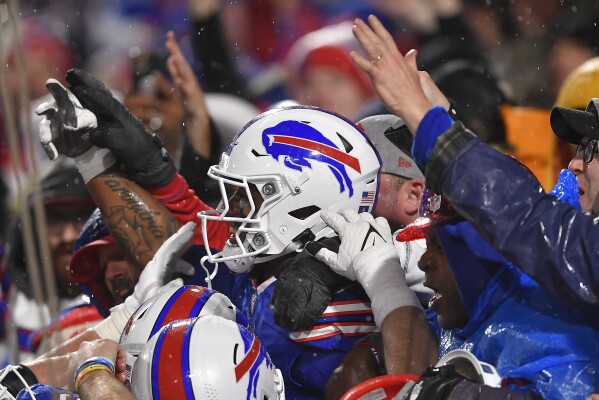 Buffalo Bills running back James Cook (4) celebrates with fans after scoring a touchdown against the Dallas Cowboys during the fourth quarter of an NFL football game, Sunday, Dec. 17, 2023, in Orchard Park, N.Y. (AP Photo/Adrian Kraus)