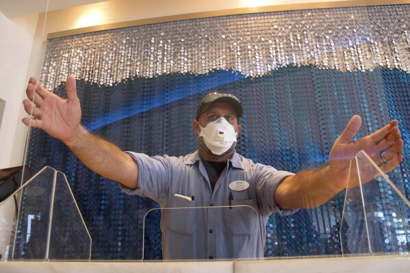 A worker at the Ocean Casino resort in Atlantic City N.J. installs a protective panel at a check-in area on June 3, 2020, about a month before it reopened during the early days of the COVID19 pandemic. On Jan. 24, 2024, the New Jersey Supreme Court rejected an attempt by the casino to collect on a business interruption policy for the 3 1/2 months it was closed due to the pandemic. (AP Photo/Wayne Parry)