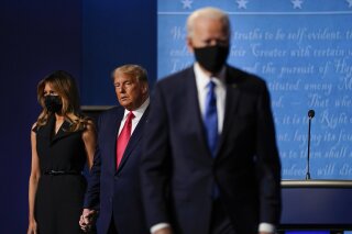 FILE - In this Oct. 22, 2020, file photo first lady Melania Trump, left, and President Donald Trump, center, remain on stage as Democratic presidential candidate former Vice President Joe Biden, right, walk away at the conclusion of the second and final presidential debate at Belmont University in Nashville, Tenn. (AP Photo/Julio Cortez, File)