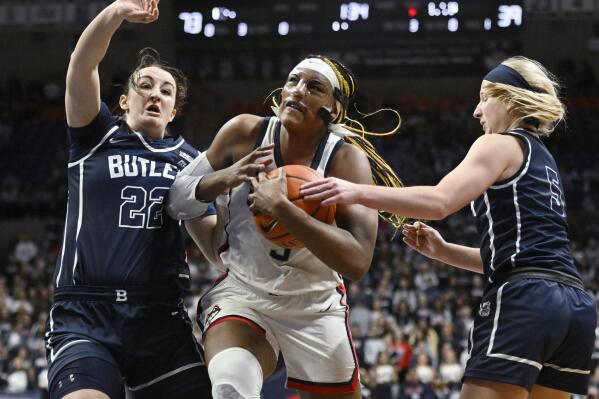 UConn's Aaliyah Edwards, center, drives to the basket as Butler's Rosemarie Dumont, left, and Shay Frederick, right, defend in the second half of an NCAA college basketball game, Saturday, Jan. 21, 2023, in Storrs, Conn. (AP Photo/Jessica Hill)