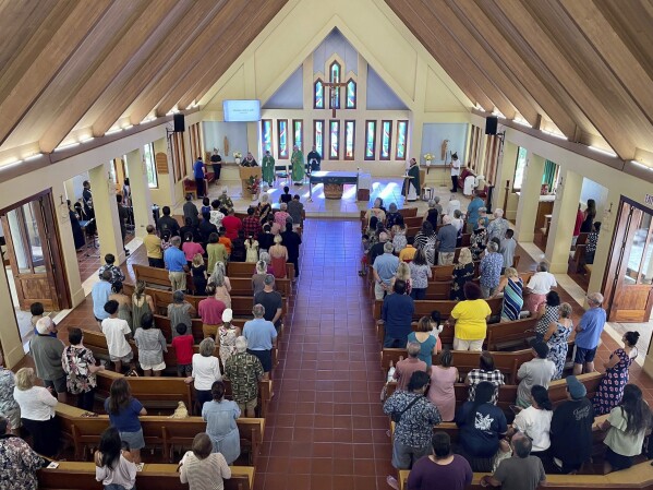 Parishioners attend Mass at Sacred Hearts Mission Church in Kapalua, Hawaii, Sunday, Aug. 13, 2023. Sacred Hearts Mission Church hosted congregants from Maria Lanakila Catholic Church in Lahaina, including several people who lost family members in fires that burned most of the Maui town days earlier. (AP Photo/Haven Daley)