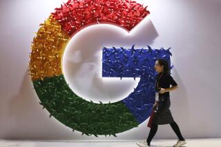 FILE - In this Monday, Nov. 5, 2018 file photo, a woman walks past the logo for Google at the China International Import Expo in Shanghai. Google has on Friday, June 11, 2021 promised to give U.K. regulators a role overseeing its plan to phase out existing ad-tracking technology from its Chrome browser as the tech giant seeks to resolve a competition investigation. The U.K. competition watchdog has been investigating Google's proposals to remove so-called third-party cookies over concerns they would undermine digital ad competition and entrench the company's market power. (AP Photo/Ng Han Guan, File)