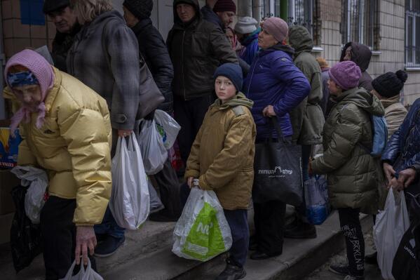 FILE - Sergei, 11, waits his turn to receive donated food during an aid humanitarian distribution in Bucha, in the outskirts of Kyiv, on Tuesday, April 19, 2022.  World hunger rose in 2021 with around 2.3 billion people facing moderate or severe difficulty obtaining food -- and that was before the Ukraine war which has sparked increases in the cost of grain, fertilizer and energy, according to a U.N. report launched Wednesday, July 6, 2022.   (AP Photo/Emilio Morenatti, File)
