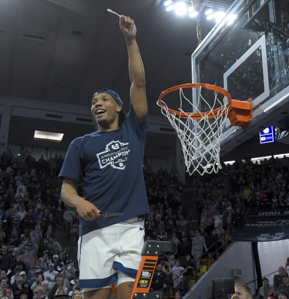 Utah State guard Darius Brown II holds up a piece of the net after the team's win over New Mexico in an NCAA college basketball game Saturday, March 9, 2024, in Logan, Utah. The victory clinched the Mountain West Conference regular-season championship for Utah State. (Eli Lucero/The Herald Journal via AP)