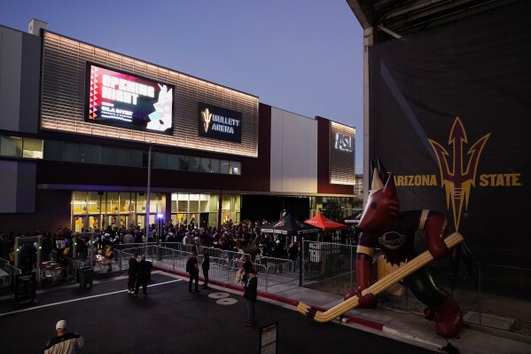 FILE - Arizona Coyotes fans wait for the doors to open prior to the Coyotes' home-opening NHL hockey game against the Winnipeg Jets at Mullett Arena in Tempe, Ariz., Oct. 28, 2022. The uncertain future of the Arizona Coyotes is a hot topic at NHL All-Star Weekend. They are playing their second season in a 5,000-seat arena on Arizona State's campus in Tempe. (AP Photo/Ross D. Franklin, File)
