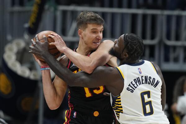 Atlanta Hawks' Bogdan Bogdanovic is defended by Indiana Pacers' Lance Stephenson during the second half of an NBA basketball game, Monday, March 28, 2022, in Indianapolis. (AP Photo/Darron Cummings)