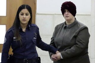 FILE - This Feb. 27, 2018, file photo, Israeli-born Australian Malka Leifer, right, is brought to a courtroom in Jerusalem. Israel's Supreme Court on Tuesday, Dec. 15, 2020, rejected an appeal challenging the extradition of Leifer, a former teacher wanted in Australia accused of sexually abusing several former students at a Jewish school in Melbourne, clearing the way for her to stand trial after a six-year legal saga. Leifer is currently on a plane to Australia, Monday, Jan. 25, 2021. (AP Photo/Mahmoud Illean, File)