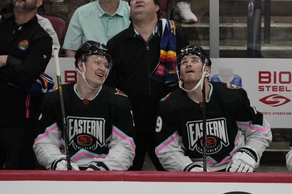 FILE - Atlantic Division's Brady Tkachuk, of the Ottawa Senators (7) and Matthew Tkachuk, of the Florida Panthers (19) watch the rerun of a goal by Matthew assisted by Brady during the NHL All Star hockey game, Saturday, Feb. 4, 2023, in Sunrise, Fla. There are 20 sets of brothers that have played in the league this season. (APPhoto/Marta Lavandier, File)