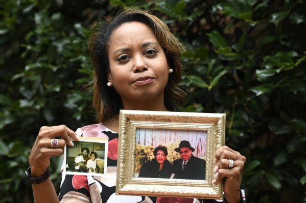 In this Sept. 6, 2019, photo, Donna Cryer holds up family photos that include her father Roland Henry, as she poses for a photo in Washington. When her father died, she tried to donate his organs, yet the local organ collection agency said no, without talking to the family or providing a reason. "It was devastating to be told there was nothing they considered worthy of donation. Nada. Not a kidney, not a liver, not tissue,” recalled Donna Cryer, president of the nonprofit Global Liver Institute and herself a recipient of a liver transplant. (AP Photo/Susan Walsh)