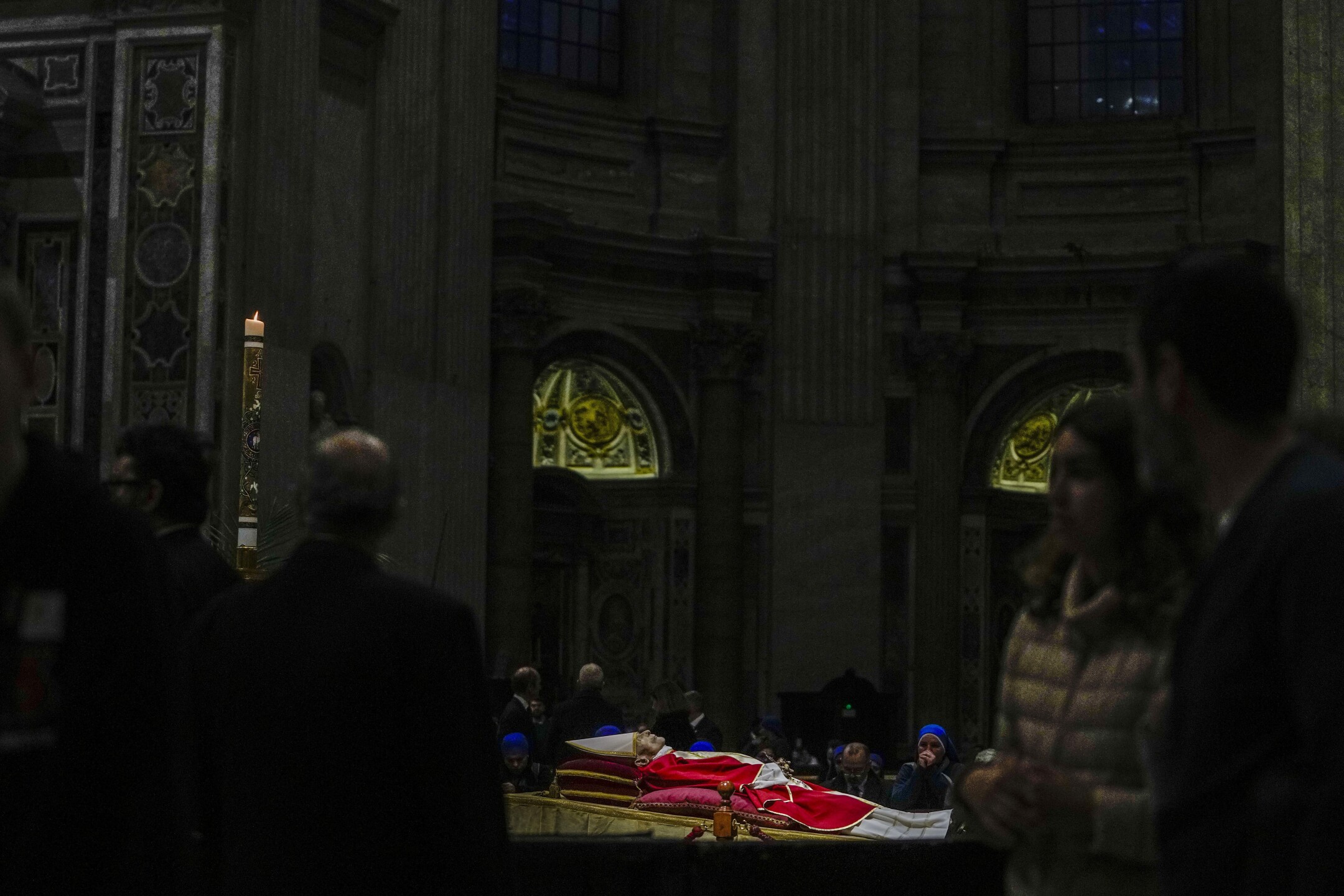 The body of the late Pope Emeritus Benedict XVI lies in state in St. Peter's Basilica at the Vatican, as mourners file by to pay tribute, on Jan. 4, 2023. Benedict died Dec. 31, 2022. He was 95. (AP Photo/Alessandra Tarantino)