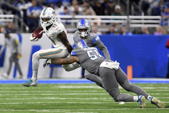 Miami Dolphins wide receiver Cedrick Wilson Jr. (11) pulls away from Detroit Lions linebacker Josh Woods (51) during the second half of an NFL football game, Sunday, Oct. 30, 2022, in Detroit. (AP Photo/Lon Horwedel)
