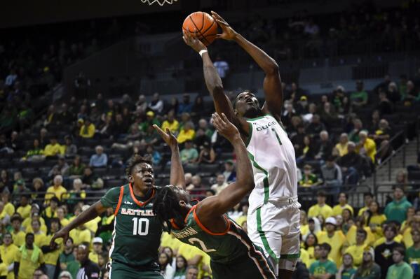 Oregon center N'Faly Dante (1) scores over Florida A&M guard Jordan Chatman (2) as forward Chase Barrs (10) comes in on the play during the first half of an NCAA college basketball game Monday, Nov. 7, 2022, in Eugene, Ore. (AP Photo/Andy Nelson)