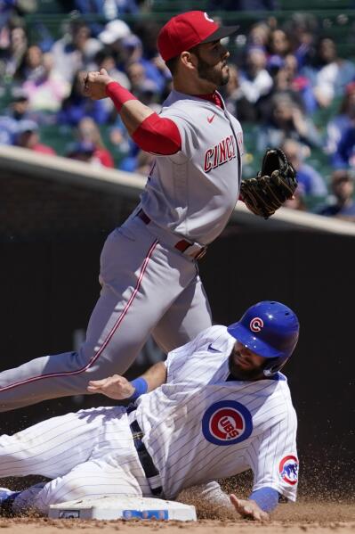 Cincinnati Reds shortstop Eugenio Suarez, top, throws out Chicago Cubs' Eric Sogard at first after forcing out David Bote during the fourth inning of a baseball game in Chicago, Saturday, May 29, 2021. (AP Photo/Nam Y. Huh)