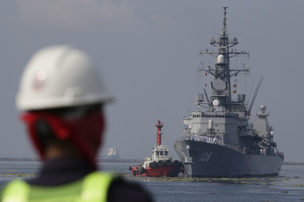 FILE - A Filipino port worker looks as the Japanese Ship Akebono (DD-108), a Murasame-class destroyer of the Japan Maritime Self-Defense Force, prepares to dock for a goodwill visit at Manila's south harbor, Philippines on Sept. 27, 2018. The United States, Japan, Australia and the Philippines will hold their first joint naval exercises, including anti-submarine warfare training, in a show of force Sunday, April 7, 2024 in the South China Sea where Beijing’s aggressive actions to assert its territorial claims have caused alarm. (AP Photo/Aaron Favila, File)