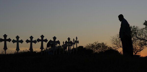 
              Isaac Hernandez and his wife Crystal visit a line of crosses before a vigil for the victims of the First Baptist Church shooting, Monday, Nov. 6, 2017, in Sutherland Springs, Texas. A man opened fire inside the church in the small South Texas community on Sunday, killing more than 20 and injuring others. (AP Photo/David J. Phillip)
            