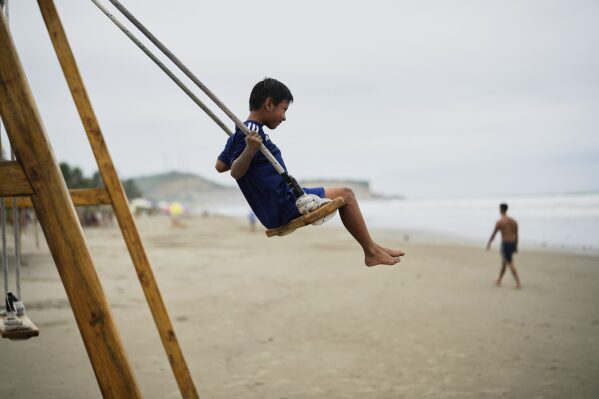 A boy swings on the beach in Olon, Ecuador, during the presidential election runoff, Sunday, April 13, 2025 (AP Photo/Fernando Vergara