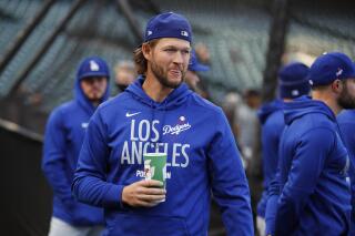 El pitcher lesionado de los Dodgers de Los Ángeles, Clayton Kershaw observa el calentamiento del equipo previo al primer juego de la Serie Divisional de la Liga Nacional contra los Gigantes de San Francisco, el viernes 8 de octubre de 2021, en San Francisco. (AP Foto/John Hefti)