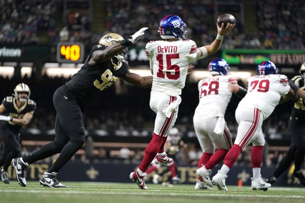 New York Giants quarterback Tommy DeVito (15) throws under pressure from New Orleans Saints defensive end Tanoh Kpassagnon (92) during the second half of an NFL football game Sunday, Dec. 17, 2023, in New Orleans. (AP Photo/Gerald Herbert)