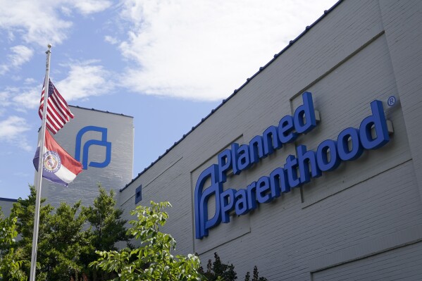 FILE - A Missouri and American flag fly outside Planned Parenthood in St. Louis, June 24, 2022. Lawmakers in Missouri are trying to defund Planned Parenthood by taking it off Medicaid rolls, even for the most basic of health care services. It's a move they've tried for years in a state where almost all abortions are already banned. (AP Photo/Jeff Roberson, File)