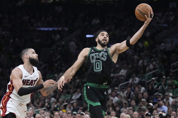 Boston Celtics forward Jayson Tatum (0) grabs a long pass against Miami Heat forward Caleb Martin, left, during the first half of Game 5 of an NBA basketball first-round playoff series, Wednesday, May 1, 2024, in Boston. (AP Photo/Charles Krupa)