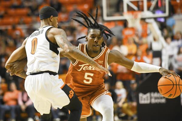 Texas guard Marcus Carr (5) tangles up with Oklahoma State guard Avery Anderson III (0) during the second half of an NCAA college basketball game Saturday, Jan. 7, 2023, in Stillwater, Okla. Texas defeated Oklahoma State 56-46. (AP Photo/Brody Schmidt)