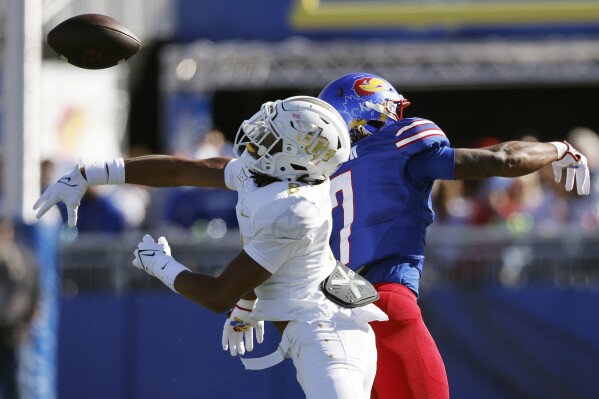 UCF defensive back Demari Henderson, left, knocks a pass away from Kansas wide receiver Trevor Wilson (7) during the first half of an NCAA football game, Saturday, Oct. 7, 2023, in Lawrence, Kan. (AP Photo/Colin E. Braley)