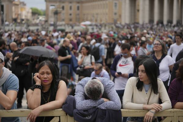 People at St. Peter's square wait to see smoke pour from the chimney of the Sistine Chapel where 133 cardinals are gathering on the second day of the conclave to elect a successor to late Pope Francis, at the Vatican, Thursday, May 8, 2025 (AP Photo/Alessandra Tarantino)