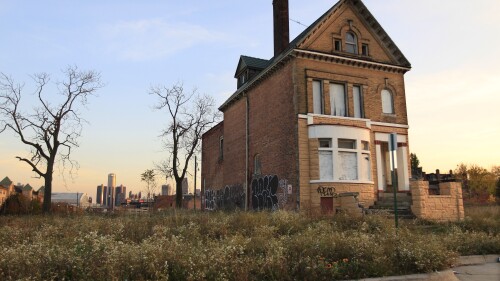 FILE - A graffiti-marked abandoned home north of downtown Detroit, in background, is seen, Oct. 24, 2013. Detroit entered 2014 in bankruptcy, facing $18 billion or more in debt. A decade later, the Motor City has risen from the ashes of insolvency, with balanced budgets, revenue increases and millions of dollars socked away. (AP Photo/Carlos Osorio, File)