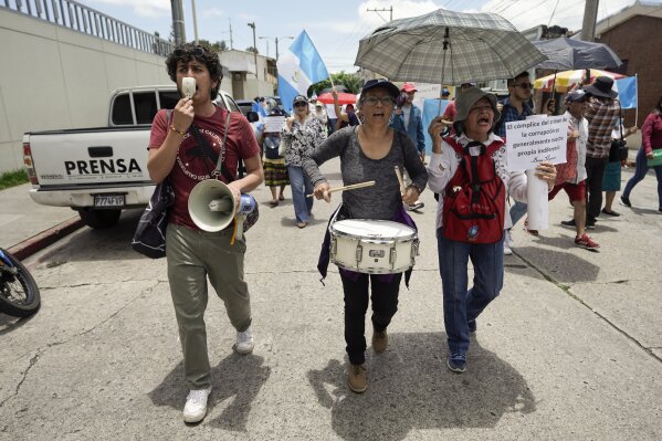 Protestors gather outside the Attorney General's Office in Guatemala City, Monday, July 24, 2023. Demonstrators are demanding respect for democracy after prosecutorial and judicial actions against the Supreme Electoral Tribunal and against one of the two parties set to participate in the presidential run-off election. (AP Photo/Moises Castillo)