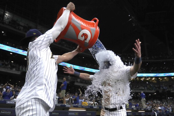 Milwaukee Brewers' Mark Canha, right, is dunked by Willy Adames after a baseball game against the Washington Nationals, Saturday, Sept. 16, 2023, in Milwaukee. (AP Photo/Aaron Gash)