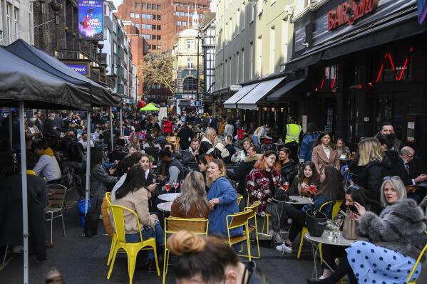 FILE - People sit, drinking and eating, outside cafes and pubs Soho, central London, April 12, 2021. Greenhouse gas emissions from the way humans consume food could add nearly one degree of warming to the Earth’s climate by 2100, according to a new study Monday, March 6, 2023. Researchers found that the majority of greenhouse gas emissions come from three major food groups — meat from animals like cows, sheep and goats, dairy and rice. (AP Photo/Alberto Pezzali, File)
