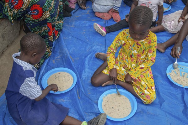 Children eat porridge prepared at a feeding center in Mudzi, Zimbabwe, on July 2, 2024. In Zimbabwe, an El Nino-induced drought is affecting millions of people, and children are most at risk. (ĢӰԺ Photo/Aaron Ufumeli)