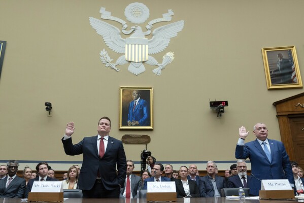 Tony Bobulinski left, and Lev Parnas are sworn in before the House Oversight and Accountability Committee hearing on Capitol Hill in Washington, Wednesday, March 20, 2024. An empty chair center, reserved for Hunter Biden, President Joe Biden's son, who did not show for the hearing. (AP Photo/Jose Luis Magana)