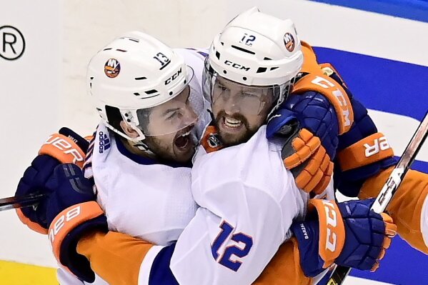 New York Islanders left wing Josh Bailey (12) celebrates his goal with teammate Mathew Barzal (13) during the second period of an NHL Stanley Cup Eastern Conference playoff hockey game in Toronto, Ontario, Tuesday, Sept. 1, 2020. (Frank Gunn/The Canadian Press via AP)