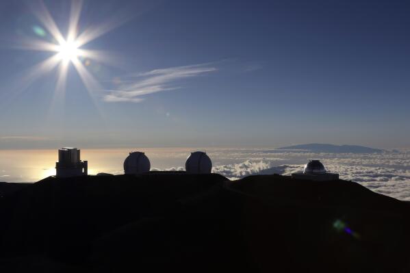 FILE - The sun sets behind telescopes on July 14, 2019, at the summit of the Big Island's Mauna Kea in Hawaii. Three House committees on Wednesday, March 2, 2022, passed legislation that would create a new governing body for the summit of Mauna Kea, the tallest peak in Hawaii and the location of some of the world's most advanced telescopes. The legislation now goes to the full House for consideration. (AP Photo/Caleb Jones, File)
