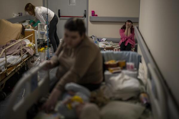 Women care for their sick children at a basement, used as a bomb shelter, at the Okhmadet children's hospital in central Kyiv, Ukraine, Monday, Feb. 28, 2022. (AP Photo/Emilio Morenatti)