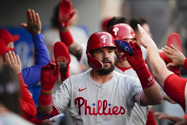 Philadelphia Phillies designated hitter Kyle Schwarber celebrates in the dugout after hitting a three-run home run to score Nick Castellanos and Bryson Stott during the second inning of a baseball game against the Los Angeles Angels, Tuesday, April 30, 2024, in Anaheim, Calif. (AP Photo/Ryan Sun)