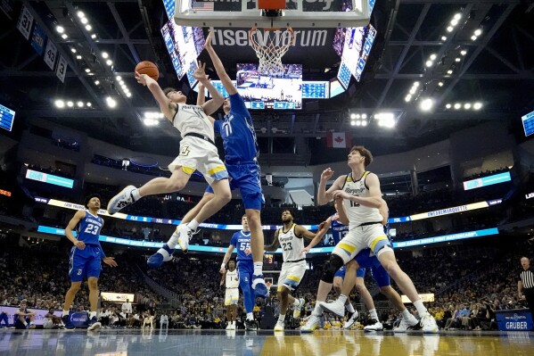 FILE - Marquette's Tyler Kolek shoots over Creighton's Ryan Kalkbrenner during the first half of an NCAA college basketball game Saturday, Dec. 30, 2023, in Milwaukee. Kolek was selected to the AP All-Big East first team in balloting released Tuesday, March 12, 2024. (AP Photo/Morry Gash, File)