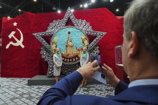 Participants pose for a photo in front of a model of the Order of Victory on the sidelines of the St. Petersburg International Economic Forum in St. Petersburg, Russia, Wednesday, June 18, 2025. (AP Photo/Dmitri Lovetsky)